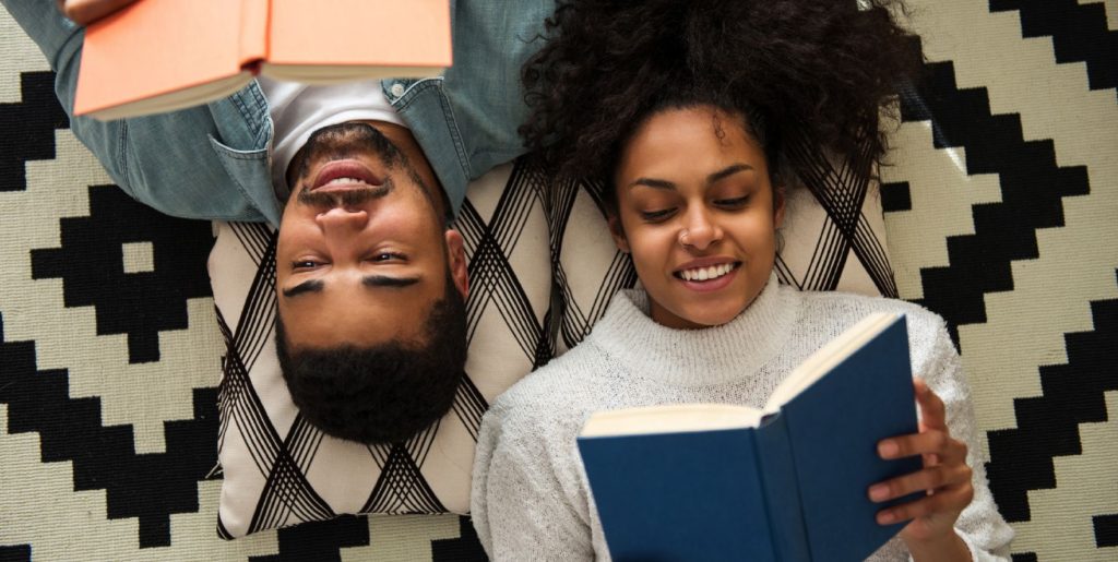 a guy and girl laying on the floor reading at Alexan Peabody