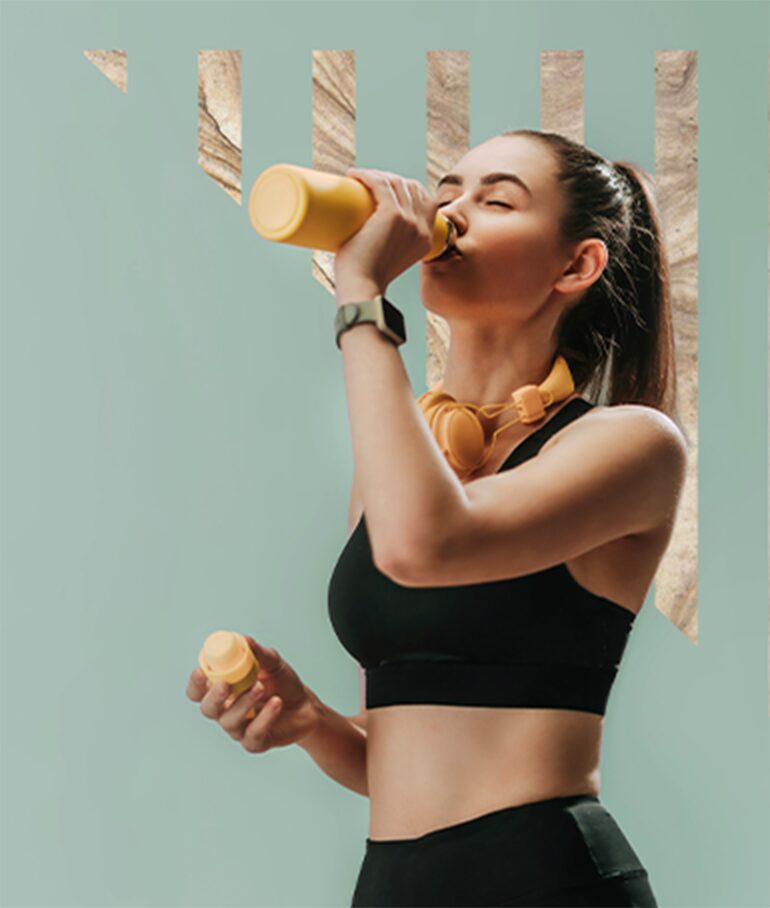 girl drinking orange water bottle wearing workout clothes.